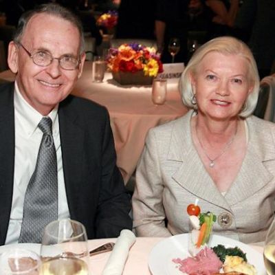 They are both sitting in the eating table as they are smiling and looking at the camera.
